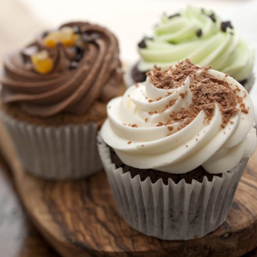 Three chocolate cupcakes with various icing and decorations